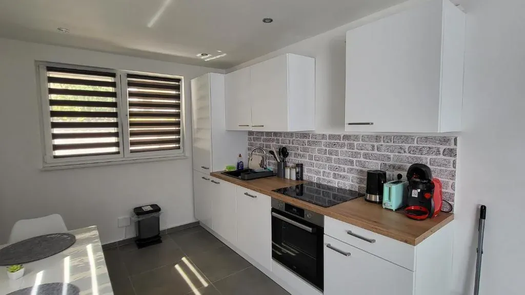 Einbauküche mit Ziegelwand und Essplatz – Modernes Apartment Erdgeschoss, Quiet Apartments Bergisch Gladbach-Refrath