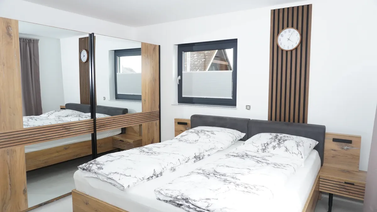 Schlafzimmer mit Doppelbett und Fenster im Premium Apartment Obergeschoss, Quiet House Pure Leverkusen